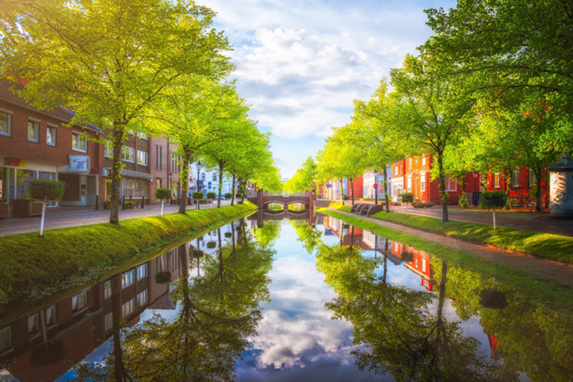 Malerischer Kanal in Papenburg, gesäumt von Bäumen und Gebäuden, mit einladender Atmosphäre