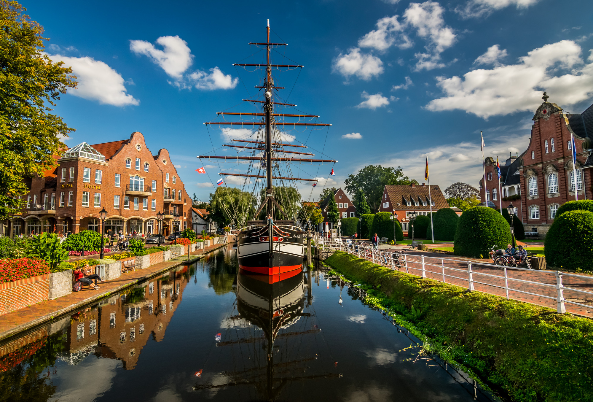 Ein Boot ist im Papenburger Hauptkanal festgemacht, neben einer Reihe von Gebäuden