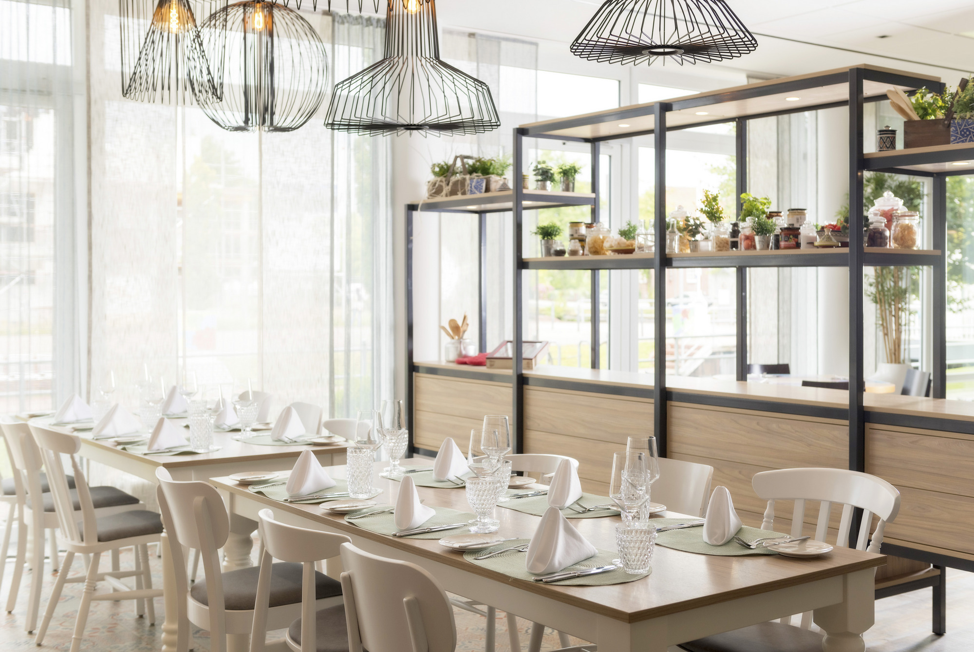 Helles Restaurant mit einem langen gedeckten Tisch und Stühlen