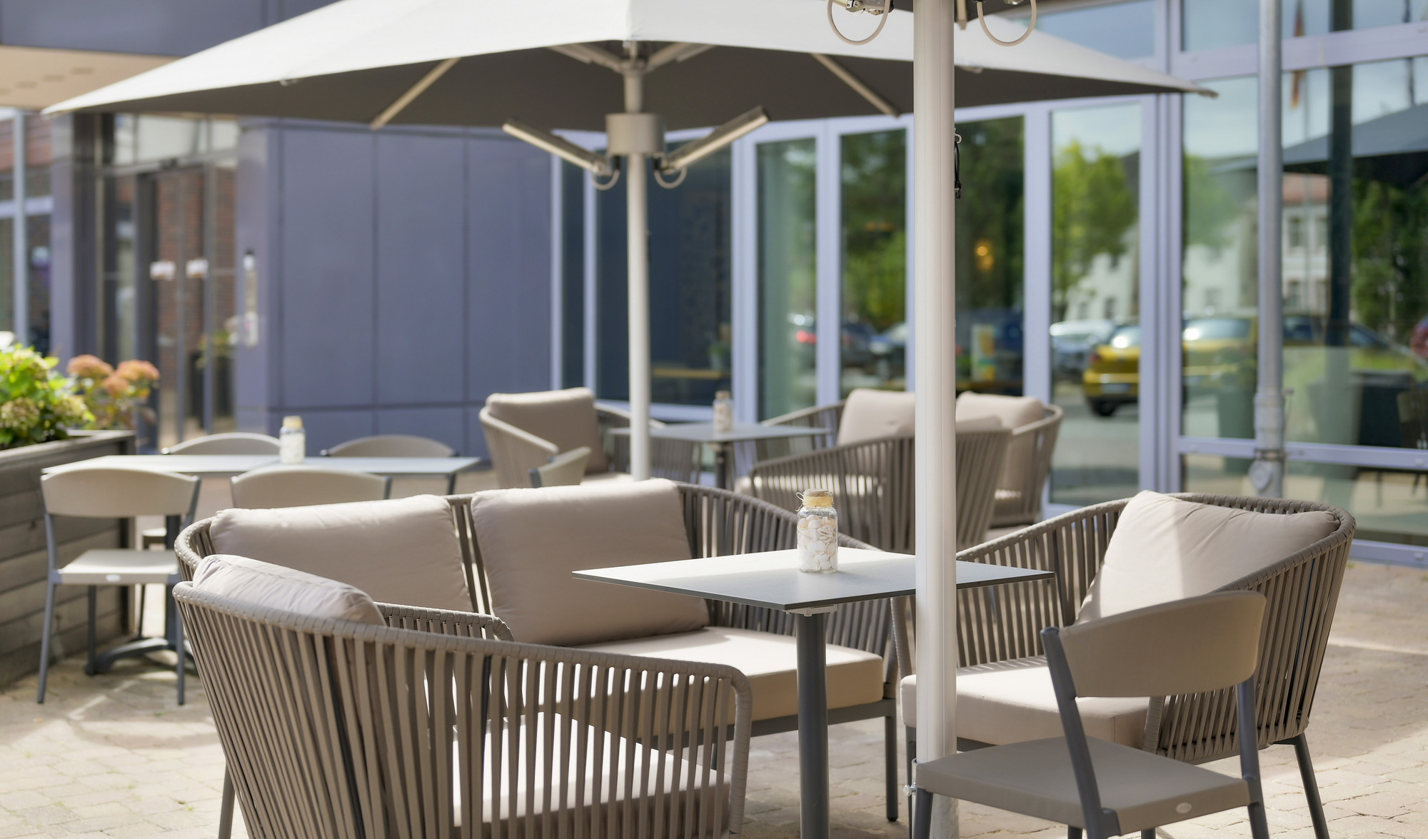 Eine sonnige Terrasse mit bequemen Stühlen und Tischen